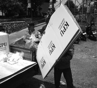 Anggota Pengawas Pemilu, Binmas polisi, dan Babinsa TNI mengawal distribusi logistik Pilkada di TPS Kampung Bojongasih, Kecamatan Dayeuhkolot, Kabupaten Bandung, Jawa Barat, 26 November 2024. TPS di kampung rawan banjir di pinggir Sungai Citarum ini menempatkan empat TPS di area paling tinggi agar terhindar banjir sebagai antisipasi. Pekan lalu kawasan Dayeuhkolot tergenang banjir luapan Sungai Citarum dengan ketinggian air antara 70 sampai 150 cm. Prima mulia