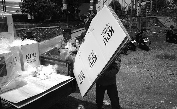 Anggota Pengawas Pemilu, Binmas polisi, dan Babinsa TNI mengawal distribusi logistik Pilkada di TPS Kampung Bojongasih, Kecamatan Dayeuhkolot, Kabupaten Bandung, Jawa Barat, 26 November 2024. TPS di kampung rawan banjir di pinggir Sungai Citarum ini menempatkan empat TPS di area paling tinggi agar terhindar banjir sebagai antisipasi. Pekan lalu kawasan Dayeuhkolot tergenang banjir luapan Sungai Citarum dengan ketinggian air antara 70 sampai 150 cm. Prima mulia