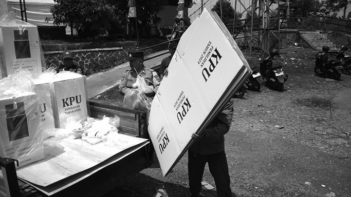 Anggota Pengawas Pemilu, Binmas polisi, dan Babinsa TNI mengawal distribusi logistik Pilkada di TPS Kampung Bojongasih, Kecamatan Dayeuhkolot, Kabupaten Bandung, Jawa Barat, 26 November 2024. TPS di kampung rawan banjir di pinggir Sungai Citarum ini menempatkan empat TPS di area paling tinggi agar terhindar banjir sebagai antisipasi. Pekan lalu kawasan Dayeuhkolot tergenang banjir luapan Sungai Citarum dengan ketinggian air antara 70 sampai 150 cm. Prima mulia